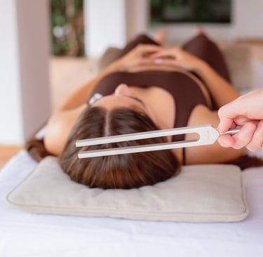 Close up of Sheila Doerfler holding the 174 Hz tuning fork above client's crown activating sun star
