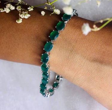 a woman's bracelet with green Emerald beads