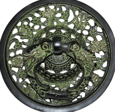 a decorative metal plate with a green dragonfly