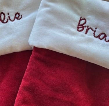 two red stockings with names embroidered on them