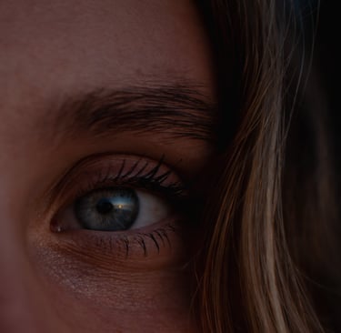 a woman with blue eyes and a toothbrush in her mouth