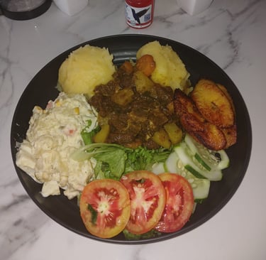 Jamaican Curry chicken with potato salad and vegetables