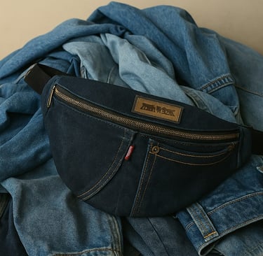 une banane lilyboo fait main en jean recycle sur un tas de jeans bleus