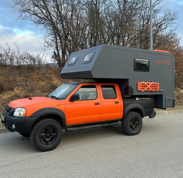 vehículo pick up de color naranja con cabina vivienda
