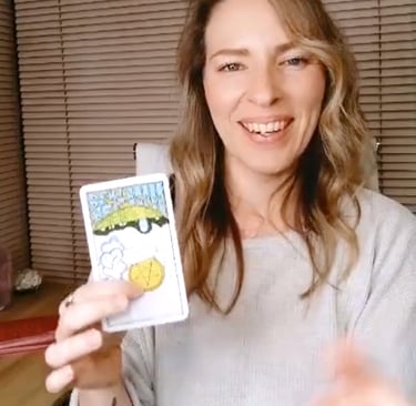 Natalie holding the Ace of Pentacles reversed during a live tarot reading.
