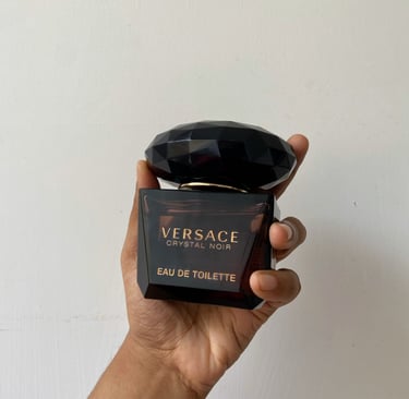 A person holding versace crystal noir