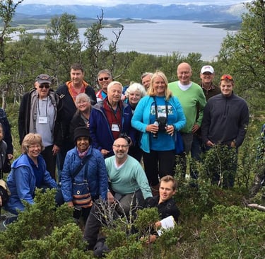 a group of Telelaget members at the top of a hill in norway overlooking a lake