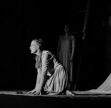 a woman in a long dress is kneeling on a stage
