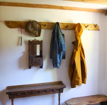 Holiday rental coat rack with jackets, a hat and a pair of boots