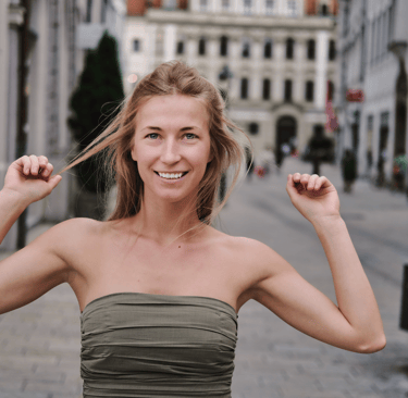 Junge Frau, die auf einer historischen gepflasterten Straße steht.  1 von 3 Varianten