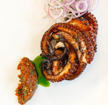 Grilled octopus with dried tomato-herbs sauce & basil oil - prepared by Villa Eats in Naxos
