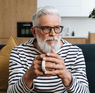 Image of male with glasses and a full head of white hair looking pensive