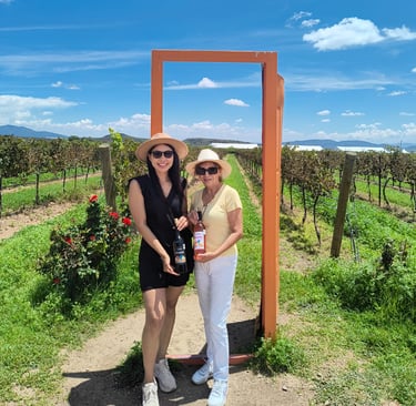 Dos mujeres con botellas de vino en viñedo de Querétaro, experiencia enológica