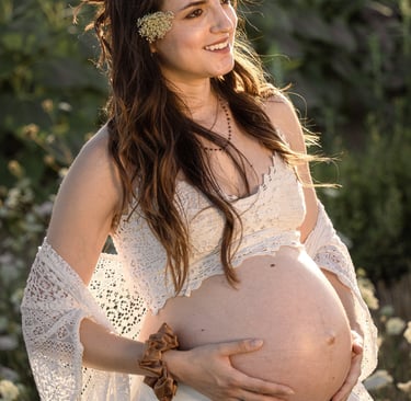a pregnant woman in a white dress and sunflowers