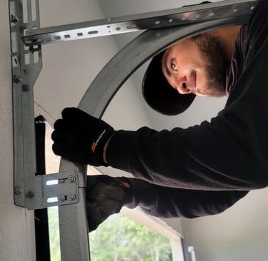 Alejandro Hernandez garage door technician performing maintenance on a garage door.