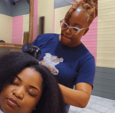Hairstylist expertly working on a customer's natural hair at Kwik Fingaz Beauty Salon in Montego Bay.