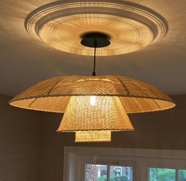 Moderne hanglamp in natuurlijke tinten en een decoratieve plafondrozet.