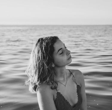 femme dans la mer jusqu'aux hanches fermant les yeux