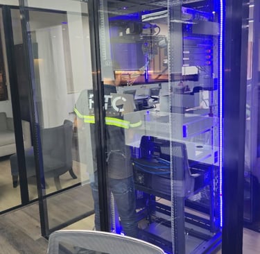 Técnico trabajando dentro de cuarto de servidores con gabinete iluminado.