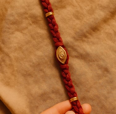 Fil rouge avec spirale dorée, symbole de structure énergétique et de transmission intuitive du soin