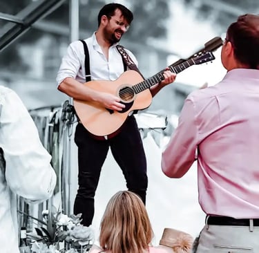 Acoustic guitarist from Rowans performing at a festival-style wedding in Devon and Cornwall