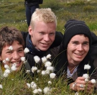 three smiling boys lying in a meadow-Telelaget