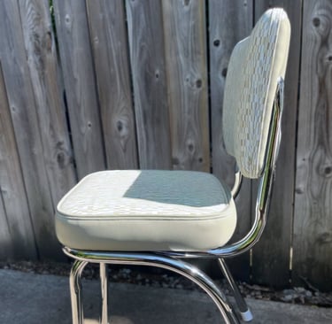 newly reupholstered vintage kitchenette chair with patterned vinyl and polished chrome legs