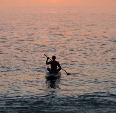 Travel writer Rick Silvia paddles into the sunset by kayak in the bay of Bang Tao