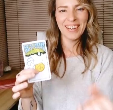Natalie holding the Ace of Pentacles reversed during a live tarot reading.
