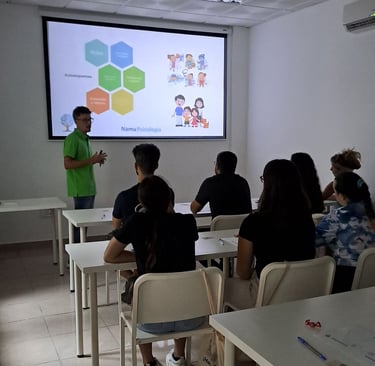a man standing in front of a classroom with a projector