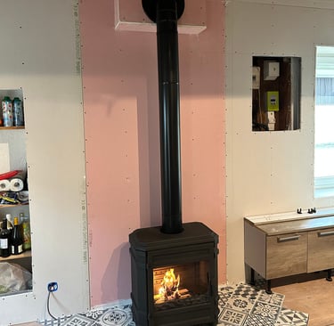 Installation de poêle à bois moderne avec habillage mural sur mesure