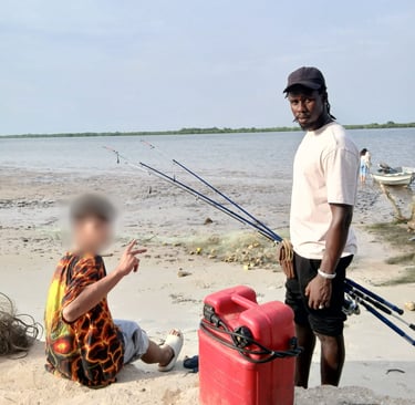 Photo d'un jeune accompagné par Kadiamor et Bourokk qui apprend à pêcher