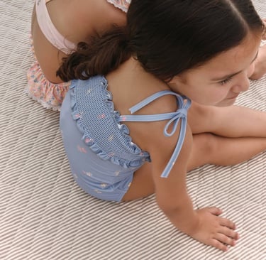 Aerial view of two girls sitting poolside in seasonal swimswear
