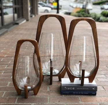 a group of three glass vases with a book on top of them