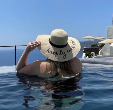 The back of a woman in a pool wearing a large sun hat