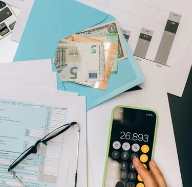 a phone, glasses, paper and a blue envelope with money on a table
