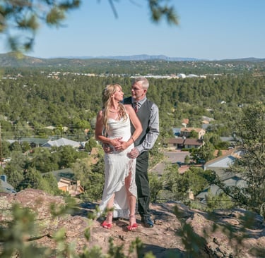 a man and woman standing on a mountain top
