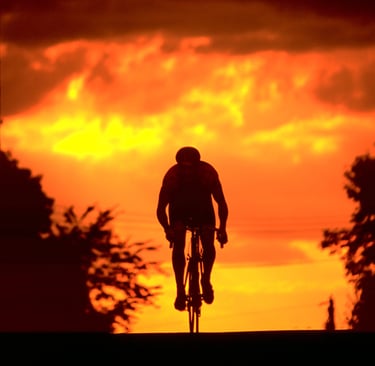 a person riding a bike at sunset