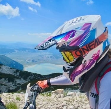 Freiheit und Fokus – Profilansicht auf dem Motorrad vor Berg- und Seekulisse