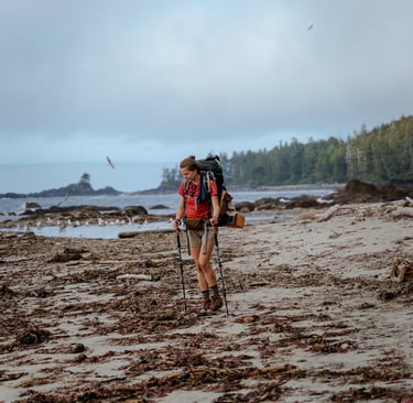 a man with a backpacker walking on a beach