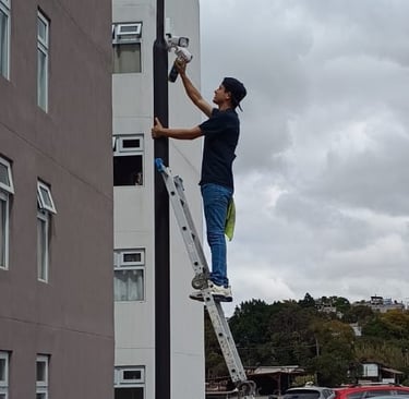 técnico realizando mantenimiento a cámaras de seguridad de un condominio