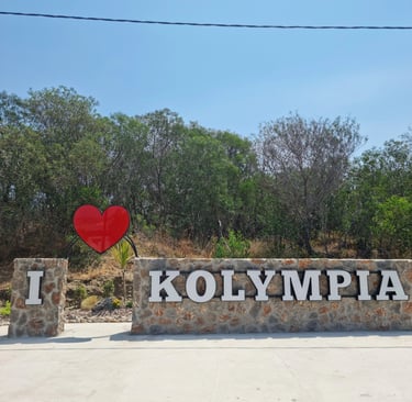 A stone monument reading I Love Kolympia with a red heart icon at the entrance to the Rhodes resort town.
