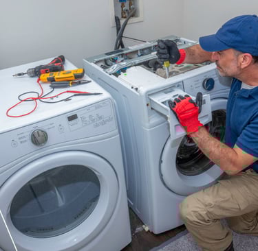 a man in a blue shirt and red gloves is fixing a washing machine