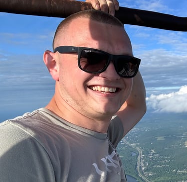 a man in sunglasses and sunglasses is smiling and holding a bat