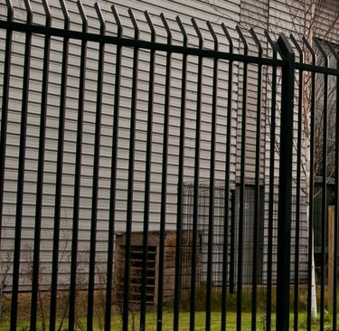 haute grille en métal devant bâtiment