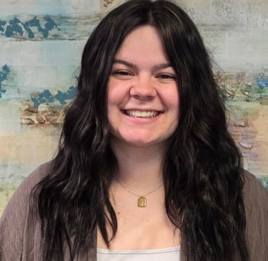 a woman with long hair and a brown jacket