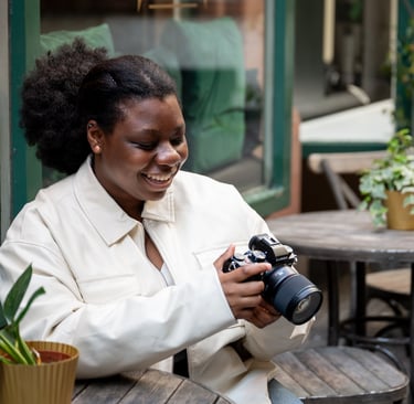 a black woman smiling in white jacket looking at outdoor photography photos