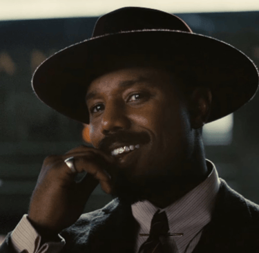 a man in a suit and tie is talking on a cell phone