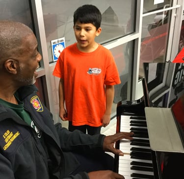 a man playing piano with a young boy singing