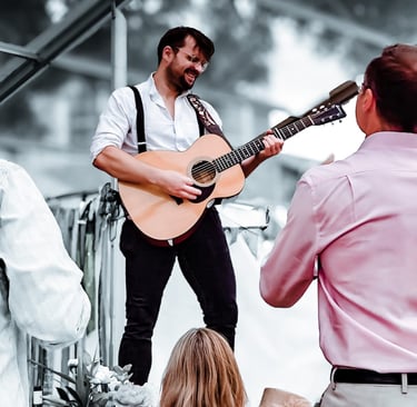 Live acoustic music performance by Rowans at a festival-themed wedding.